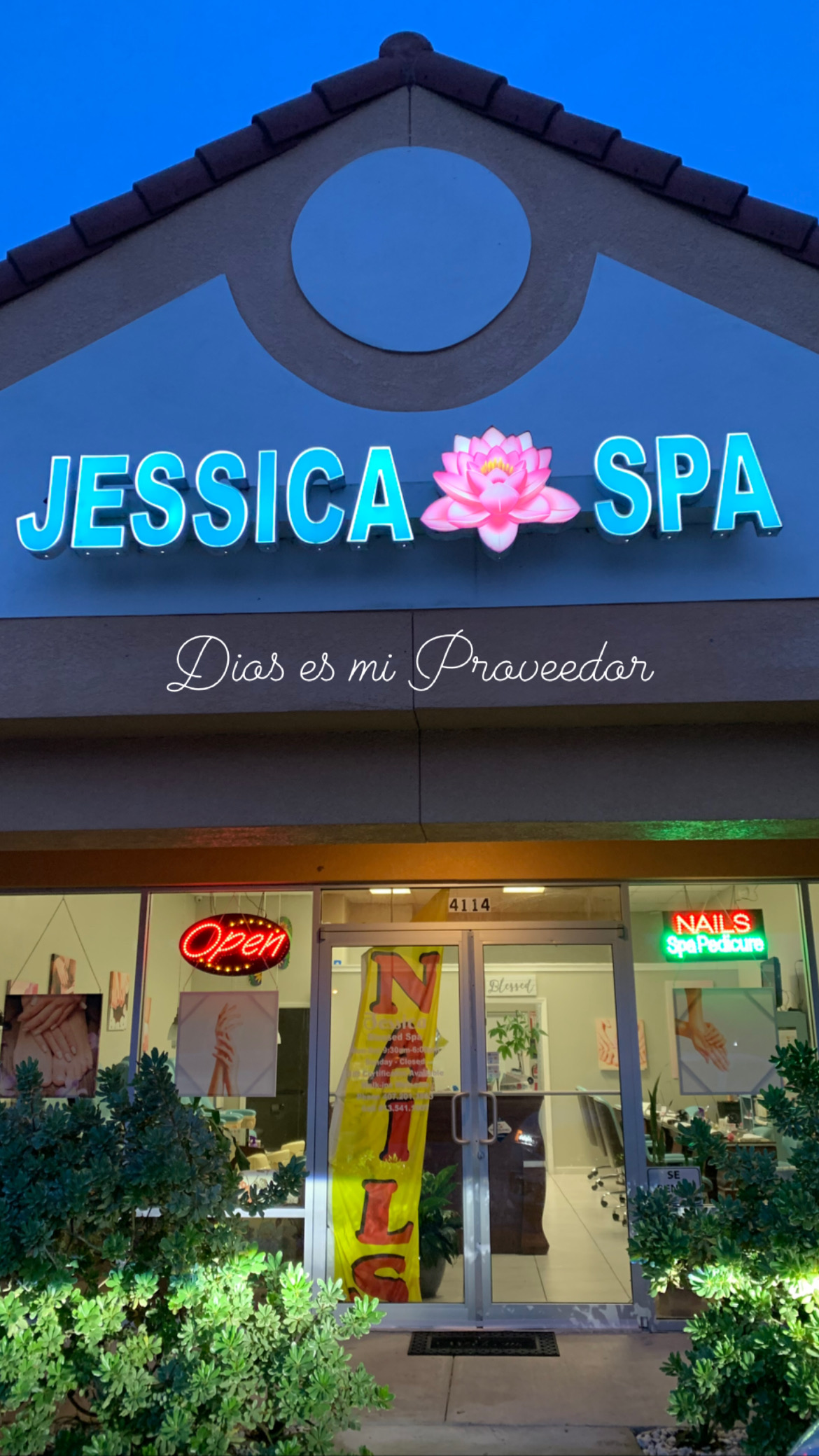 The elegant storefront of Jessica Blessed Spa in Kissimmee, Florida. The image showcases a modern, high-end retail exterior with large glass windows revealing a warm, wooden-themed interior with plush seating and soft ambient lighting. The atmosphere is sophisticated, feminine, and welcoming, perfectly aligned with the luxury spa's branding.